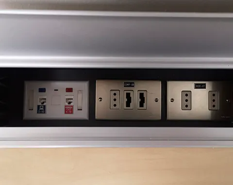 Estación de conectividad con puntos de red y enchufes eléctricos en escritorio