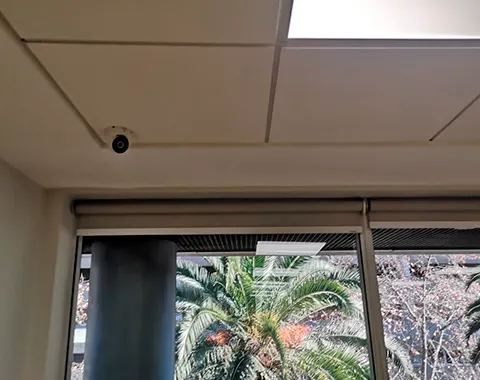 Cámara de seguridad instalada junto a ventanal de oficina