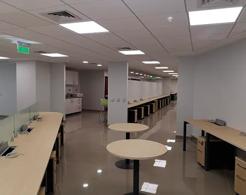 Espacio de trabajo colaborativo con mobiliario y luminarias instaladas