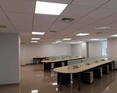 Oficina abierta con iluminación de paneles LED en cielo americano