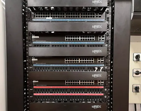 Rack de comunicaciones con switches y patch panels ordenados